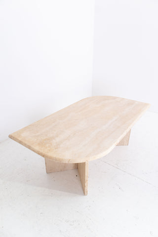 travertine coffee table on a white floor with a white wall background