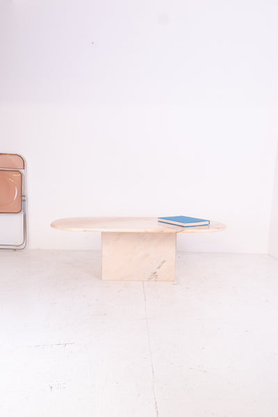 Oval pink marble table with a book on a white background
