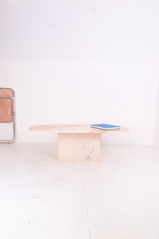 Oval pink marble table with a book on a white background