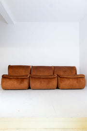 Modular vintage brown sofa against a white wall