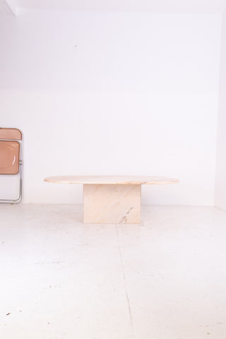 Minimalist Oval pink marble coffee table with a white wall and floor in the background