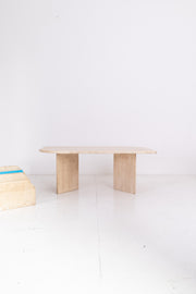 travertine coffee table on a white floor with a white wall background