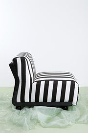 Side view of vintage B&B Amanta chair by Bellini against white background and green floor