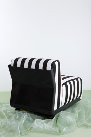 view of rear of Amanta 24 chair against white background and green floor