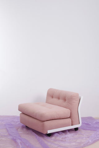 pink vintage Mario Bellini armchair against a white backdrop and a textured purple floor 