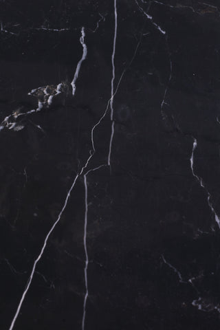 Detail shot of black stone and white veining on retro marble side table.