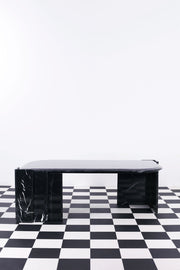 Vintage black marble tulip shaped coffee table against white background and black and white floor