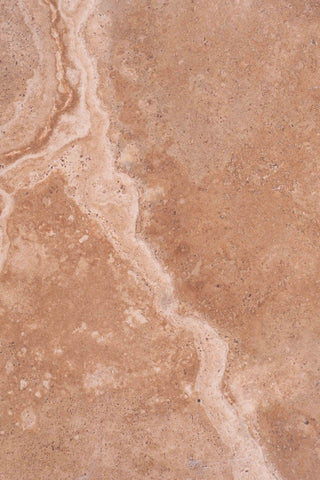 close up view of the grain pattern of sand coloured marble with veining 