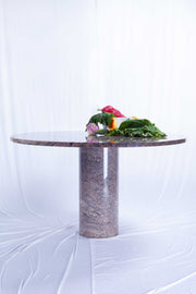 Round granite dining table with draped whit fabric background