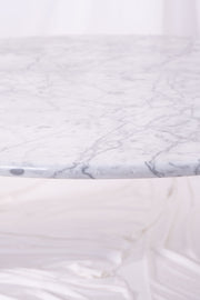 Shot of signs of wear on large white marble coffee table. Image taken against white drapes.