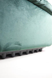 Green velvet armchair with protective plastic base